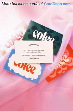 three business cards sitting on top of a pink sheet