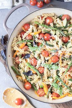 a pan filled with pasta and vegetables on top of a table