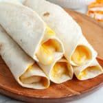 three tortillas sitting on top of a wooden plate