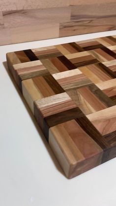 a wooden cutting board sitting on top of a white counter next to a knife block