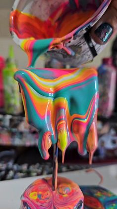 someone is pouring melted paint onto a cake