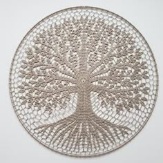 an intricately designed metal tree on a white wall