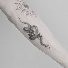 a black and white photo of a person's arm with a tattoo on it