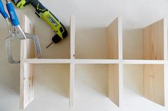 tools are sitting on top of wooden shelves with pegs and pliers next to them