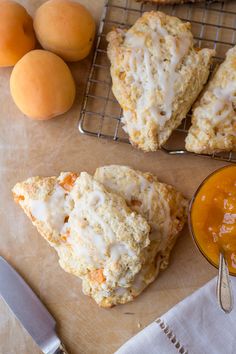 scones with icing sitting on a table next to apricots and orange juice