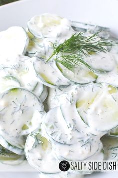 cucumber salad with dill dressing in a white bowl