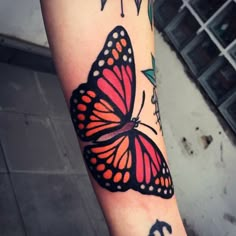 a colorful butterfly tattoo on the arm