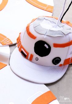 an orange and white baseball cap with a star wars character on it