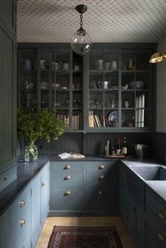 a kitchen with blue cabinets and an area rug