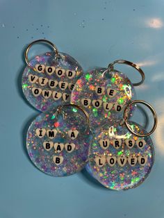 four keychains with words on them that say i'm a bad b