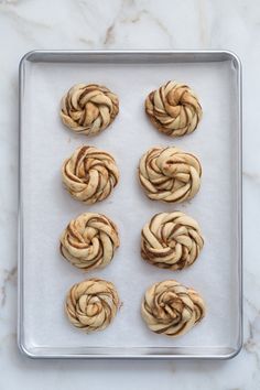 six cinnamon buns on a baking sheet ready to be baked