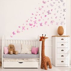 a baby's room with a giraffe and butterflies on the wall