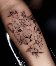 a black and white photo of a leopard with flowers on it's head is shown