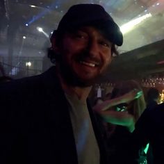 a man standing in front of a crowd at a bar with his hand up to the camera