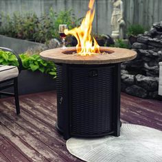 a fire pit sitting on top of a wooden deck next to a glass of wine