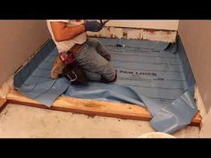 a man laying down insulation on the floor