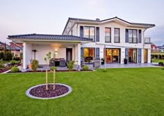 a large white house sitting on top of a lush green field