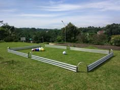 an empty soccer field in the middle of a grassy area with balls on the ground