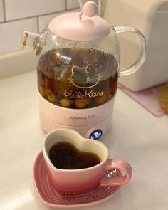 a cup of coffee next to a tea pot