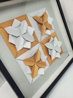 an origami piece is displayed in a frame