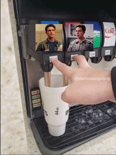 a hand is pressing the button on a coffee machine that has pictures of people in it