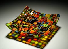 a multicolored glass bowl sitting on top of a table