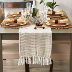 a dining table with place settings and plates on it