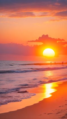 the sun is setting over the ocean and people are walking in the water at the beach