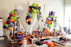 a table topped with lots of balloons and decorations