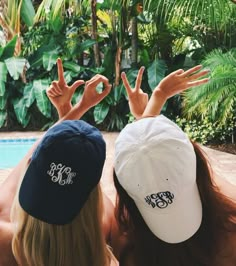 two people sitting next to each other near a pool