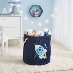 a child's room with blue walls, white carpet and toys in a toy storage bin