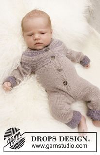 a baby laying on top of a white rug wearing a knitted sweater and pants