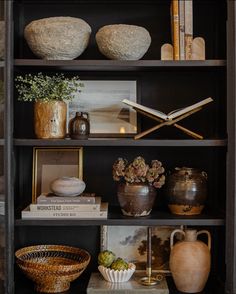 a bookshelf filled with vases and other items