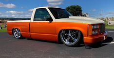 an orange and white truck parked in a parking lot