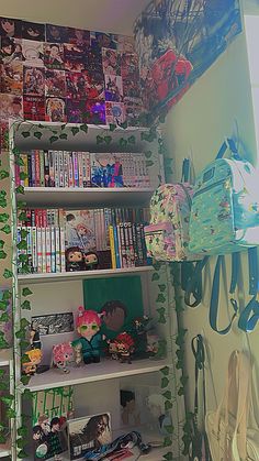 a book shelf filled with lots of books next to a wall covered in comic books