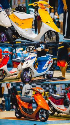 several different colored scooters are on display