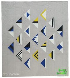 a quilted wall hanging with triangles on it