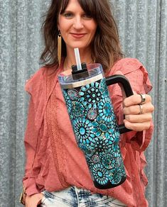 a woman holding a cup with a straw in it