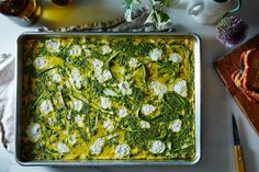 a casserole dish with spinach and feta cheese in it on a table