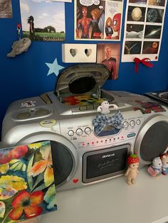 there is a boombox on top of the desk with pictures and toys around it