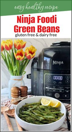 a bowl filled with green beans next to an air fryer and some yellow tulips