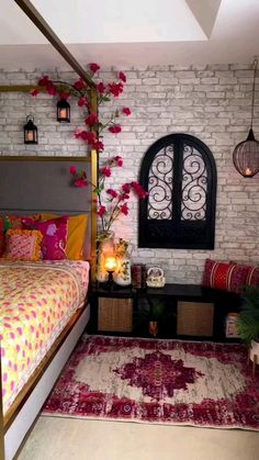 a bed room with a neatly made bed next to a table and flowers on the wall