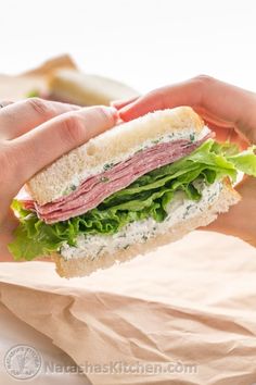 a person holding a sandwich in their hands