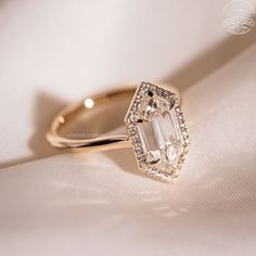 an engagement ring is shown on a white cloth