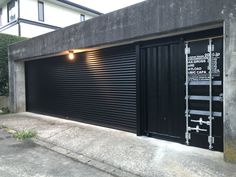 a black garage door sitting next to a building