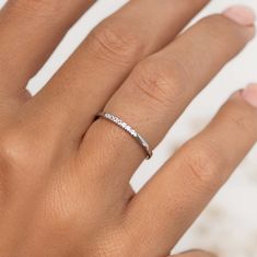 a woman's hand with a white diamond ring on her left hand and the word love written across it