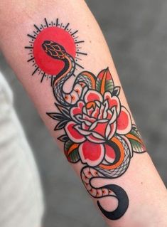 a woman's arm with a flower and snake tattoo on it