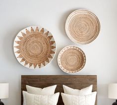 a bed with two baskets on the wall above it, and another set of pillows