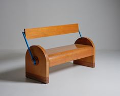 a wooden bench sitting on top of a white floor next to a gray wall with blue handles