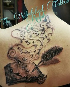 the back of a woman's shoulder with an ink pen and quill on it